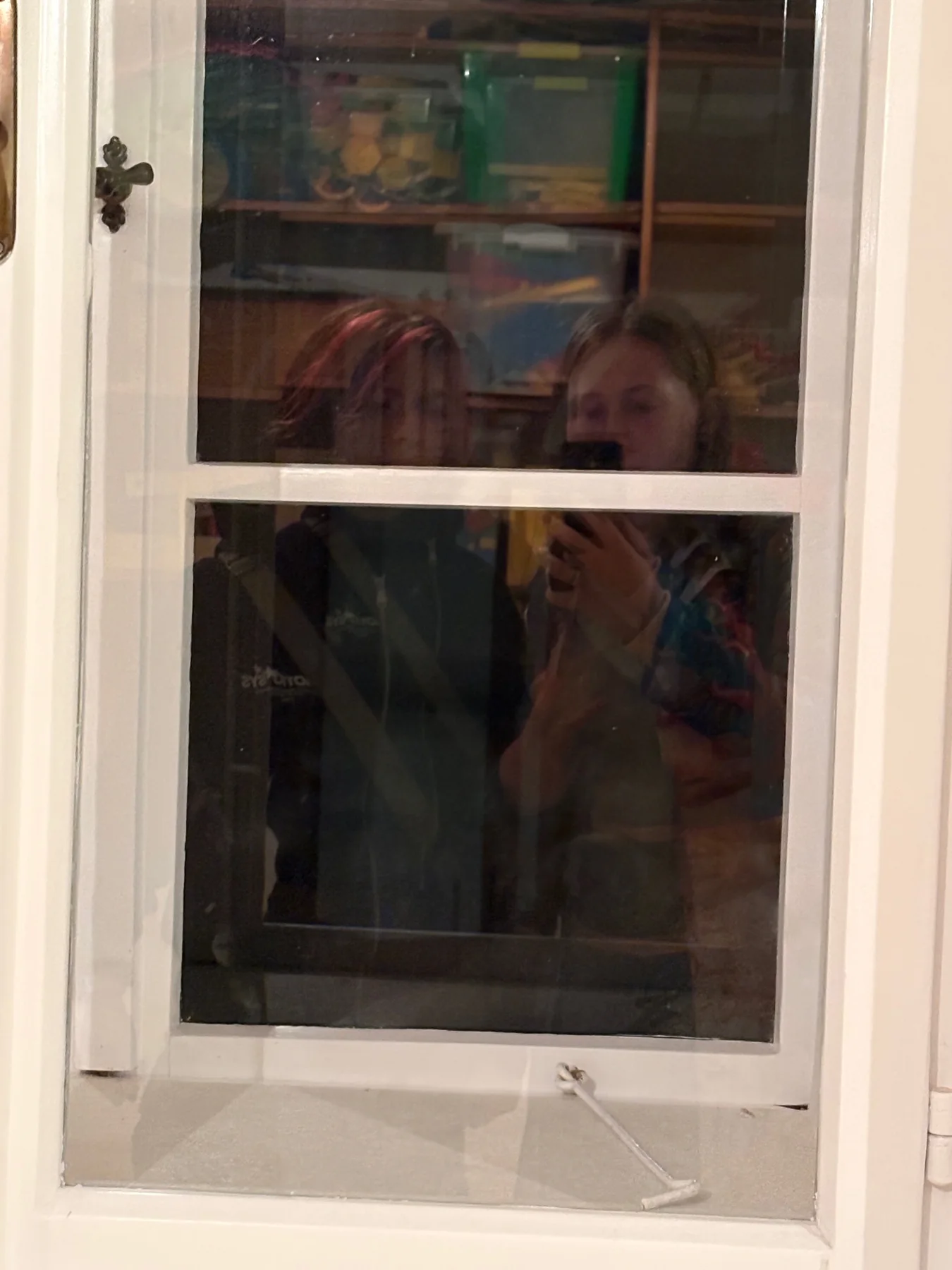 A playful silhouette behind a window during a Scout meeting